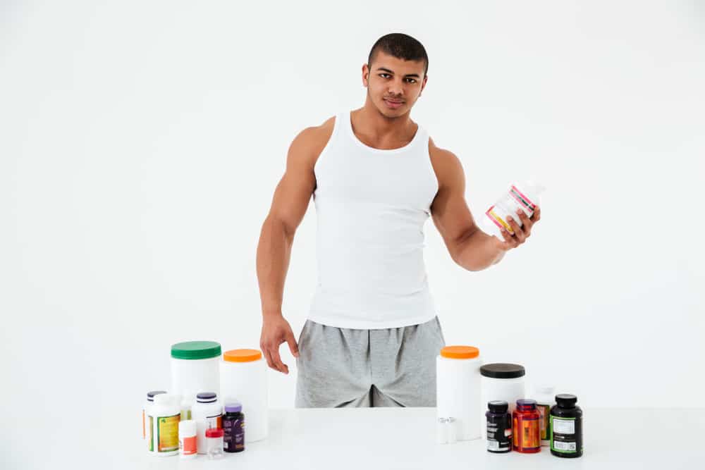 sportsman holding vitamins sport pills